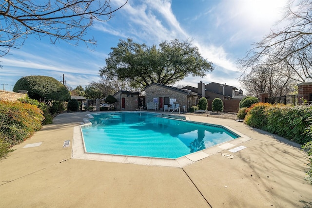 pool with a patio and fence