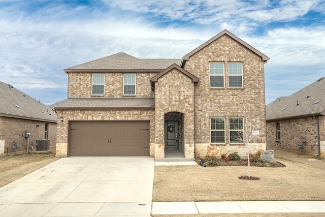 view of front of property featuring brick siding, a shingled roof, concrete driveway, an attached garage, and cooling unit