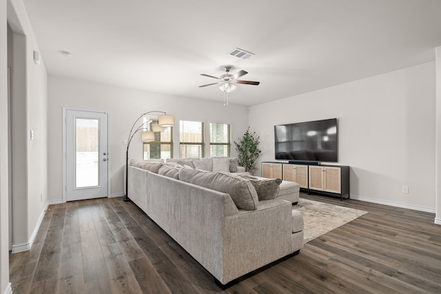 living room featuring dark wood-style floors, baseboards, visible vents, and ceiling fan