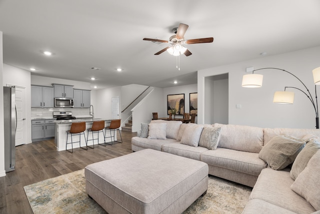 living room with ceiling fan, stairway, wood finished floors, and recessed lighting