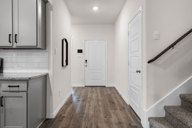 interior space featuring dark wood-style floors, stairs, and baseboards