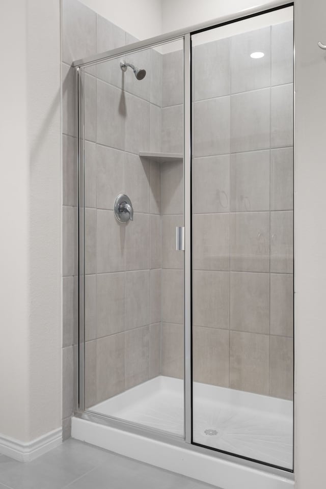 full bathroom featuring a stall shower and baseboards