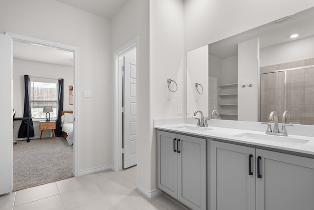 full bathroom with double vanity, a tile shower, a sink, and tile patterned floors