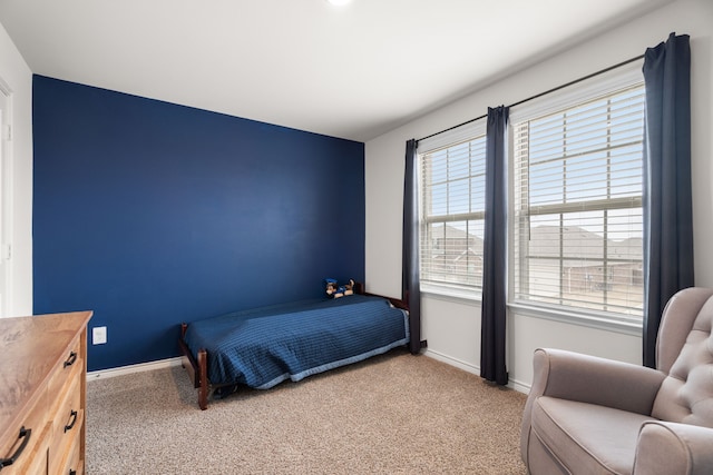 bedroom featuring light carpet and baseboards