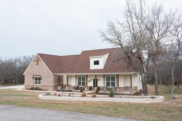 view of front of house featuring a porch and brick siding