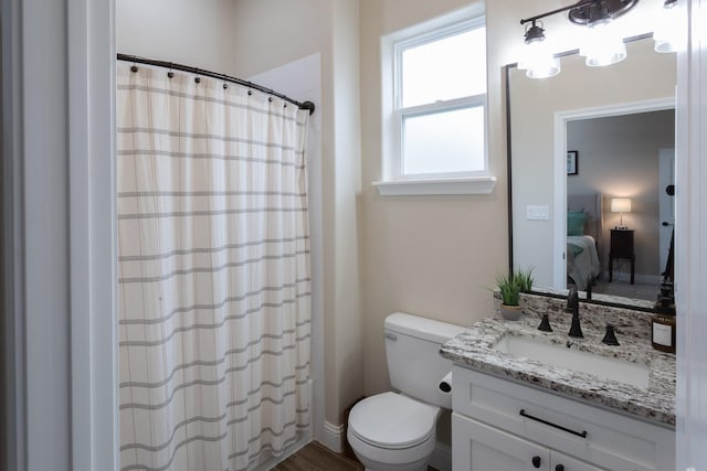 ensuite bathroom featuring a shower with shower curtain, vanity, toilet, and ensuite bathroom