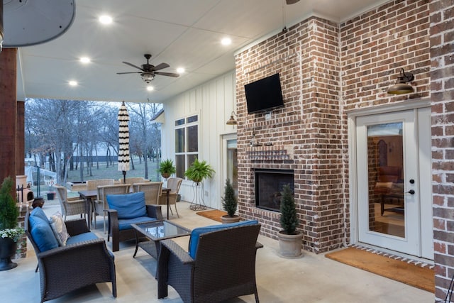 view of patio / terrace featuring an outdoor living space with a fireplace, outdoor dining area, and a ceiling fan