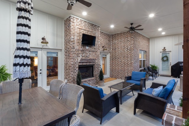 living room with a brick fireplace, ceiling fan, brick wall, and recessed lighting