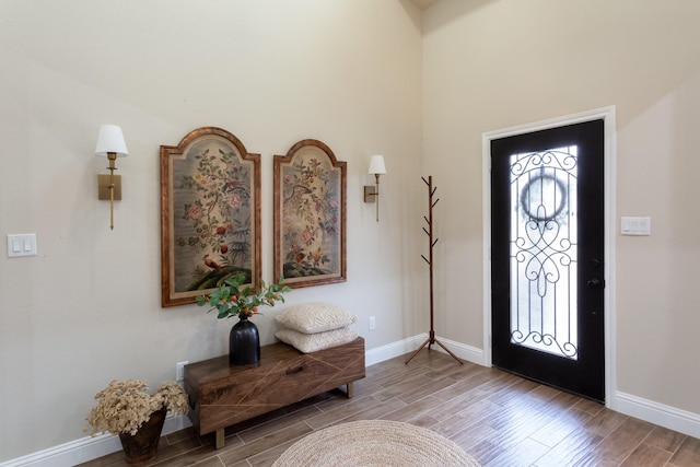 foyer entrance with wood finish floors and baseboards