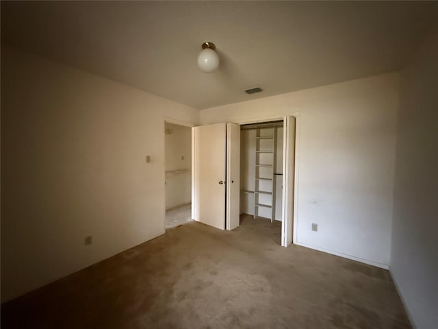 unfurnished bedroom with carpet, visible vents, and a closet