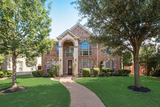 traditional-style house with brick siding and a front lawn