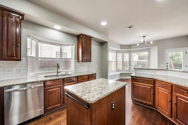 kitchen with a sink, visible vents, dark wood finished floors, and stainless steel dishwasher