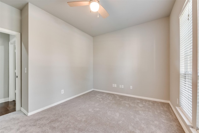 empty room featuring carpet floors, baseboards, and a ceiling fan