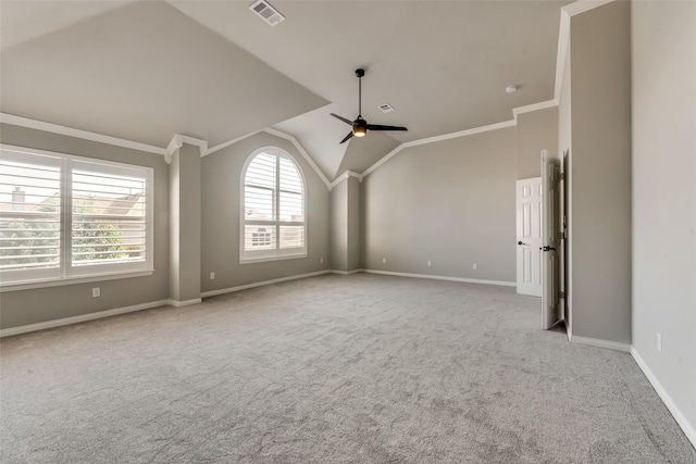 carpeted empty room featuring baseboards, visible vents, a ceiling fan, ornamental molding, and vaulted ceiling