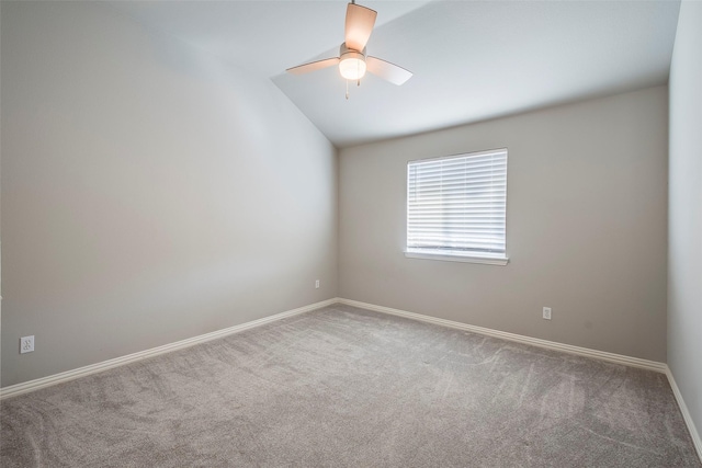 spare room with carpet floors, ceiling fan, baseboards, and vaulted ceiling