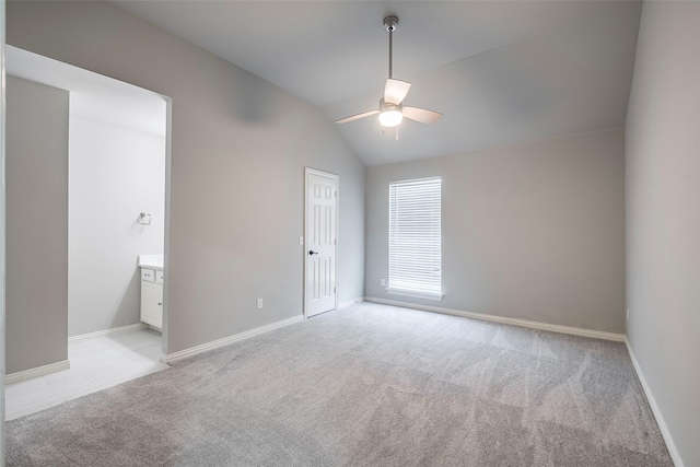 unfurnished room with light carpet, ceiling fan, vaulted ceiling, and baseboards