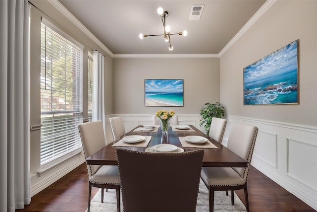 dining space with dark wood-type flooring, an inviting chandelier, visible vents, and crown molding