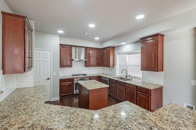 kitchen featuring recessed lighting, stainless steel appliances, a sink, visible vents, and wall chimney exhaust hood