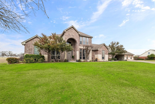 view of front of house with brick siding, driveway, and a front lawn