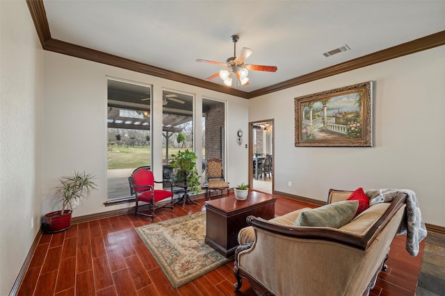 living area featuring baseboards, visible vents, a ceiling fan, wood finished floors, and crown molding