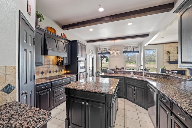 kitchen with dark cabinets, a sink, appliances with stainless steel finishes, tasteful backsplash, and beamed ceiling