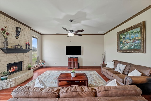 living room with ornamental molding, a large fireplace, baseboards, and wood finished floors