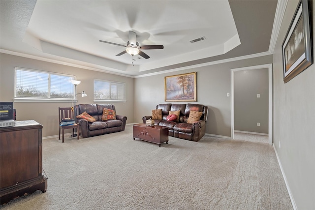 living area featuring a tray ceiling, carpet, visible vents, and baseboards