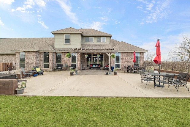 back of property with brick siding, roof with shingles, a lawn, a pergola, and a patio area