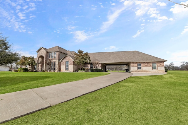 french country home with a carport, brick siding, and a front lawn