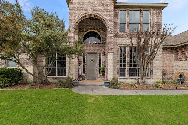 view of front of house featuring a front yard and brick siding