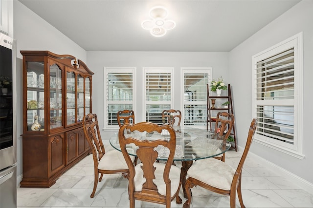 dining area with marble finish floor and baseboards