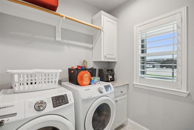 laundry room featuring cabinet space, baseboards, and separate washer and dryer