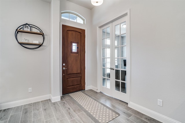 entrance foyer with french doors, wood finish floors, and baseboards