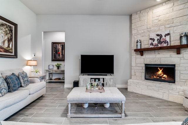 living area featuring baseboards, a fireplace, and wood tiled floor