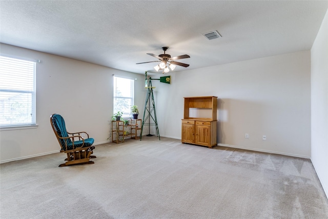 unfurnished room with visible vents, light carpet, ceiling fan, a textured ceiling, and baseboards