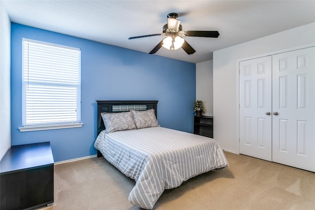 carpeted bedroom featuring a closet, ceiling fan, and baseboards