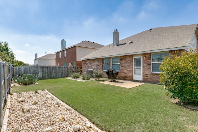 back of house with a patio area, brick siding, a yard, and a fenced backyard