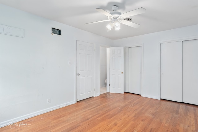 unfurnished bedroom featuring a ceiling fan, light wood-style flooring, baseboards, and two closets