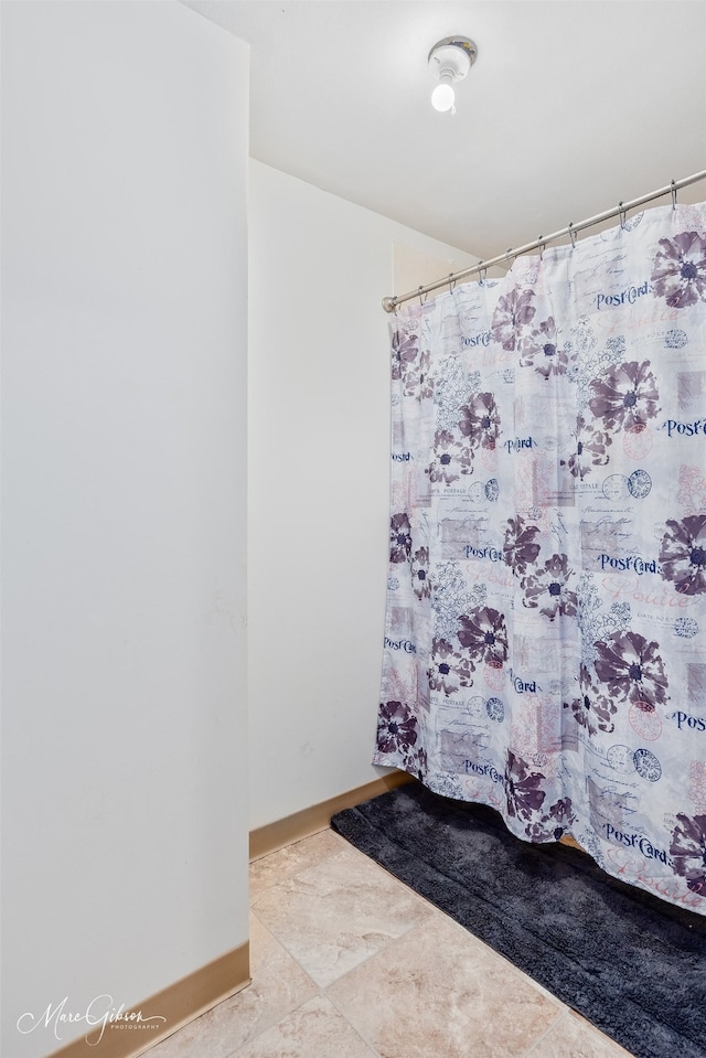 bathroom featuring a shower with curtain and baseboards