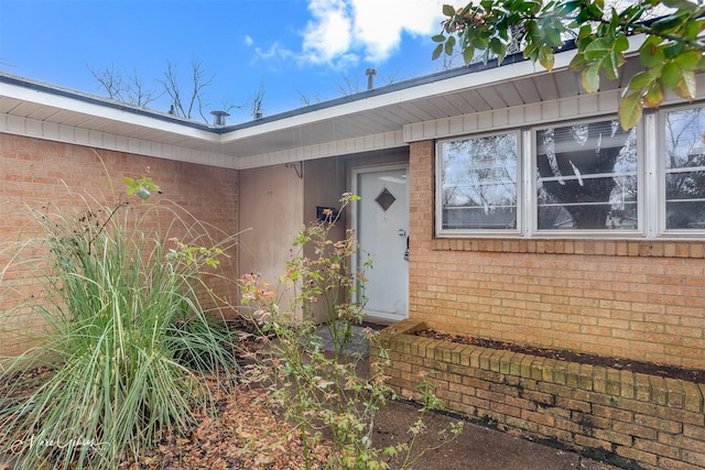 view of exterior entry with brick siding