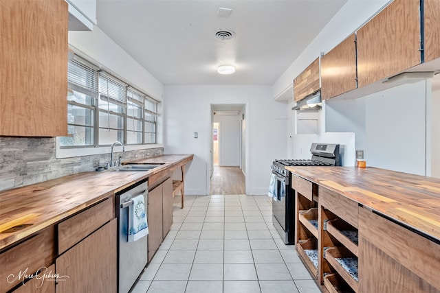 kitchen with light tile patterned floors, a sink, visible vents, wooden counters, and appliances with stainless steel finishes