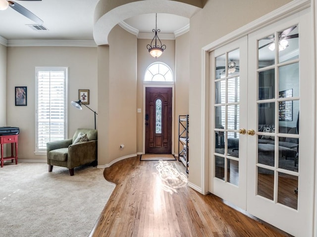 foyer entrance featuring a ceiling fan, french doors, visible vents, and crown molding