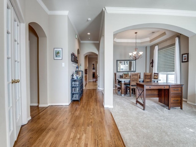 interior space with ornamental molding, a chandelier, light wood-style flooring, and baseboards