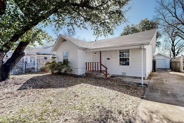 view of front of home featuring a garage, fence, a shingled roof, and an outdoor structure