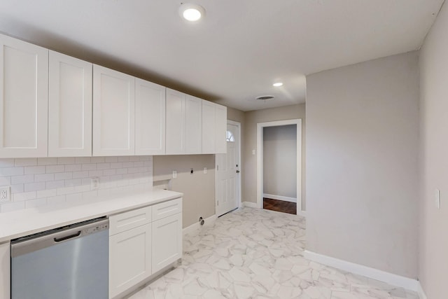 kitchen featuring white cabinets, marble finish floor, stainless steel dishwasher, light countertops, and backsplash