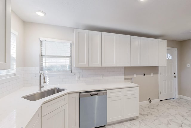 kitchen with a sink, marble finish floor, a wealth of natural light, and stainless steel dishwasher