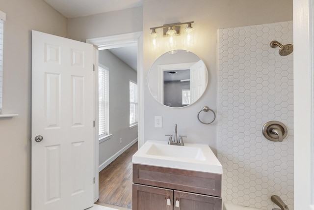 bathroom with wood finished floors, vanity, and baseboards