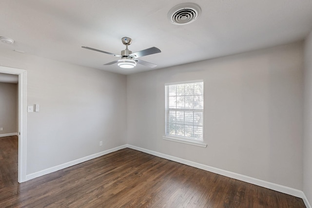 unfurnished room with dark wood-type flooring, visible vents, ceiling fan, and baseboards