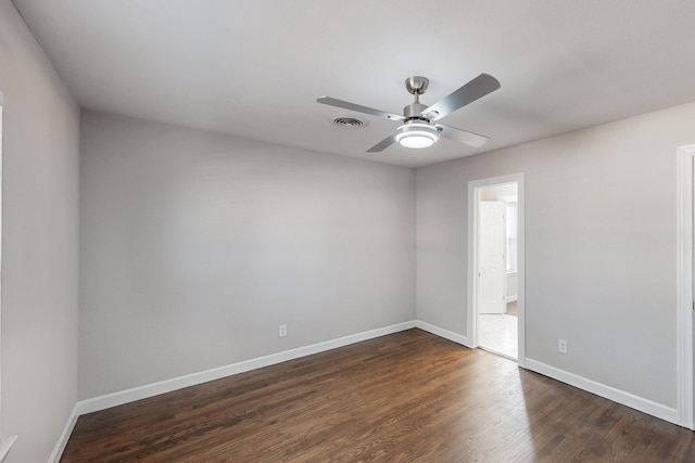 unfurnished room with dark wood-style floors, ceiling fan, and baseboards