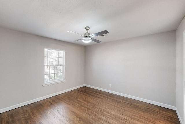 unfurnished room with ceiling fan, baseboards, and dark wood-type flooring